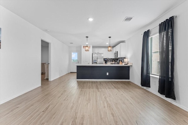 126 Spring Rose Dr, Magnolia, TX 77354 - kitchen with appliances with stainless steel finishes, white cabinetry, a peninsula, light countertops, and light wood-style floors