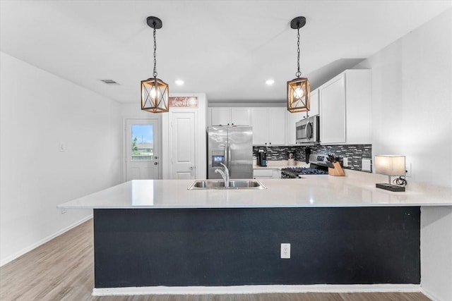126 Spring Rose Dr, Magnolia, TX 77354 - kitchen featuring stainless steel appliances, a sink, light countertops, a peninsula, and baseboards