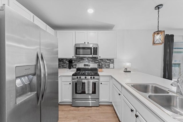 126 Spring Rose Dr, Magnolia, TX 77354 - kitchen featuring appliances with stainless steel finishes, white cabinetry, light countertops, light wood-style flooring, and a sink