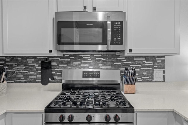126 Spring Rose Dr, Magnolia, TX 77354 - kitchen with appliances with stainless steel finishes, white cabinets, and tasteful backsplash