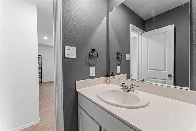 126 Spring Rose Dr, Magnolia, TX 77354 - bathroom with vanity, wood finished floors, a textured wall, and baseboards