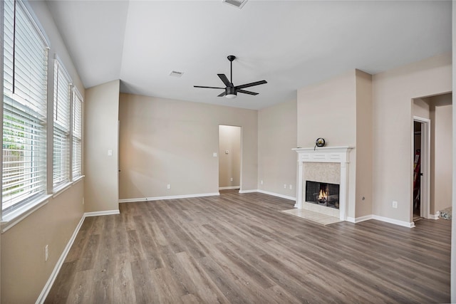 unfurnished living room with baseboards, ceiling fan, wood finished floors, and a fireplace