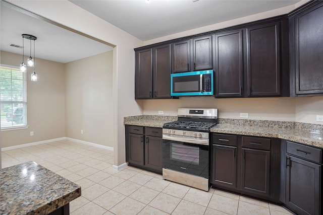 kitchen with dark brown cabinetry, light tile patterned flooring, light stone countertops, baseboards, and appliances with stainless steel finishes