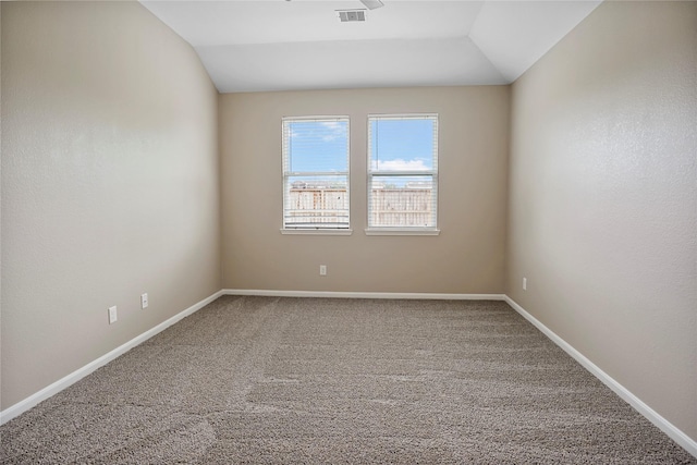 carpeted spare room featuring baseboards, lofted ceiling, and visible vents
