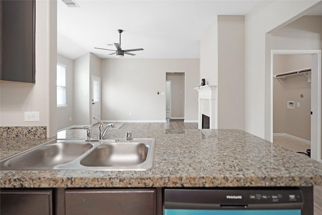 kitchen with wood finished floors, open floor plan, ceiling fan, a sink, and dishwasher