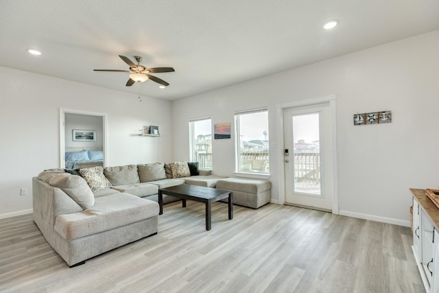 living area with light wood finished floors, a ceiling fan, recessed lighting, and baseboards