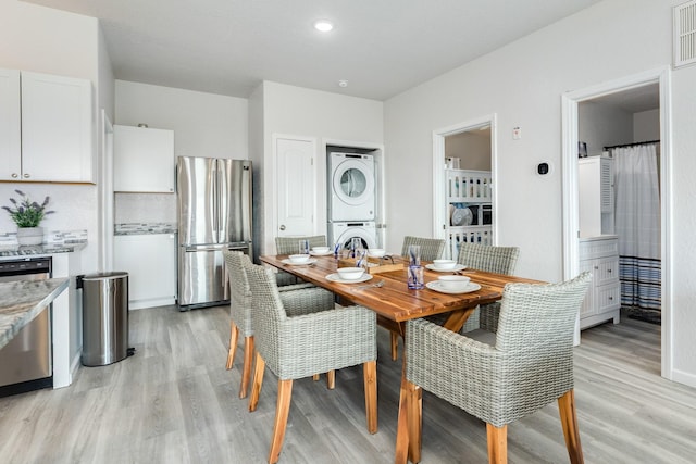 dining room featuring stacked washer / drying machine, light wood-type flooring, recessed lighting, and visible vents