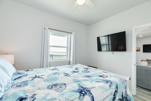bedroom with a ceiling fan, baseboards, and light wood-type flooring