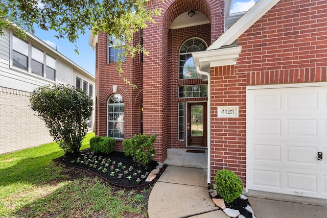 entrance to property with brick siding and a garage