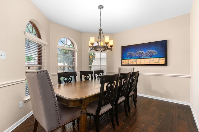 dining area with wood finished floors, a chandelier, and baseboards