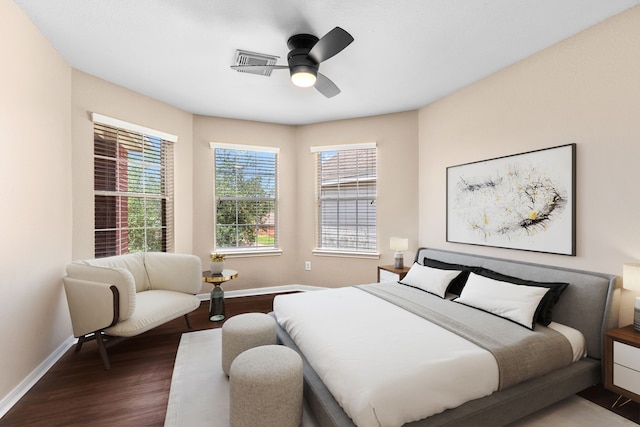 bedroom with dark wood-style flooring, visible vents, a ceiling fan, and baseboards