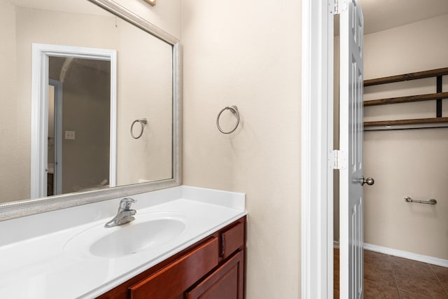 bathroom with vanity, tile patterned flooring, and baseboards