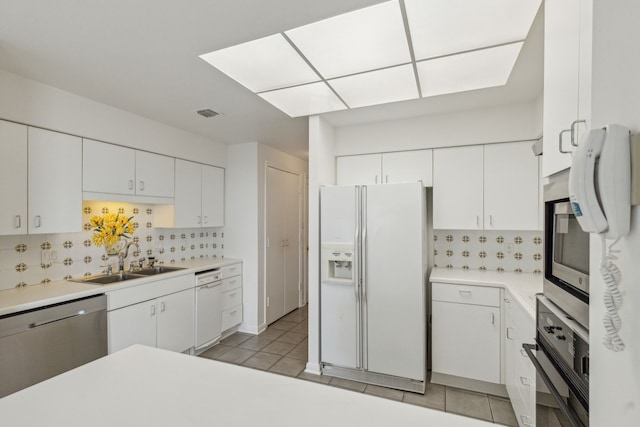 101 Westcott St Unit 1402, Houston, TX 77007 - kitchen featuring white fridge with ice dispenser, stainless steel dishwasher, a sink, black oven, and backsplash