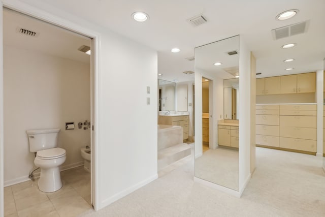 101 Westcott St Unit 1402, Houston, TX 77007 - bathroom featuring baseboards, vanity, toilet, recessed lighting, and a bidet