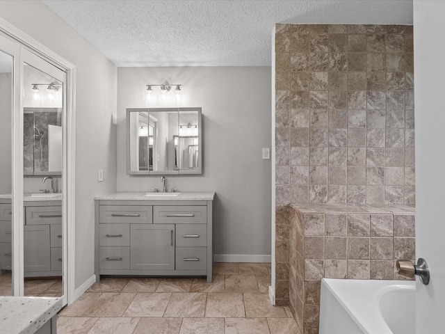 307 Binnacle Way, Crosby, TX 77532 - bathroom featuring a washtub, a textured ceiling, baseboards, and vanity