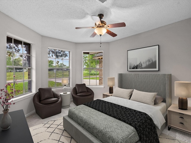 307 Binnacle Way, Crosby, TX 77532 - bedroom featuring light colored carpet, a ceiling fan, a textured ceiling, and multiple windows