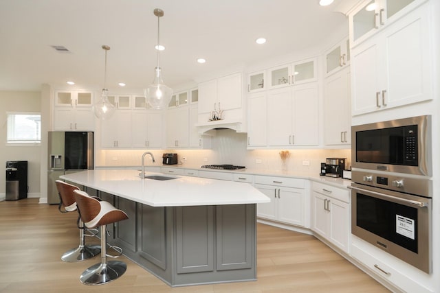 kitchen featuring light countertops, stainless steel appliances, light wood-type flooring, and a sink