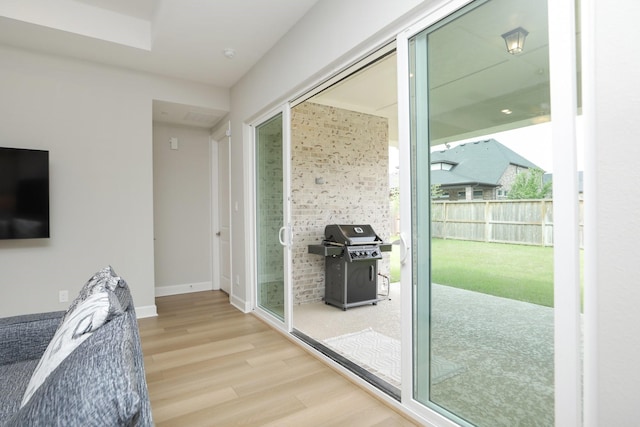 doorway to outside with wood finished floors and baseboards