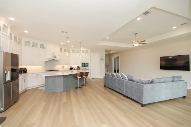 living room featuring light wood finished floors, recessed lighting, visible vents, and ceiling fan