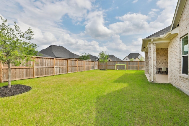 view of yard featuring a fenced backyard, a residential view, and a patio area