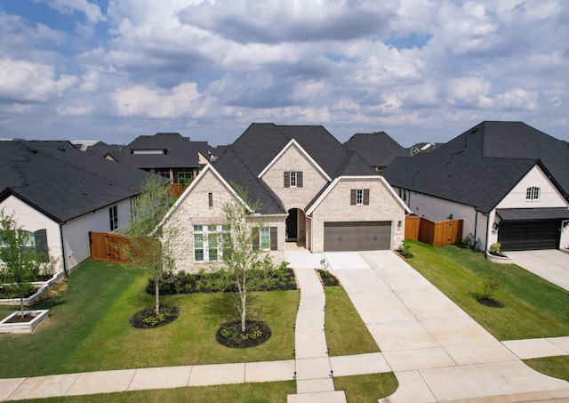 view of front facade featuring fence, driveway, a front yard, and brick siding