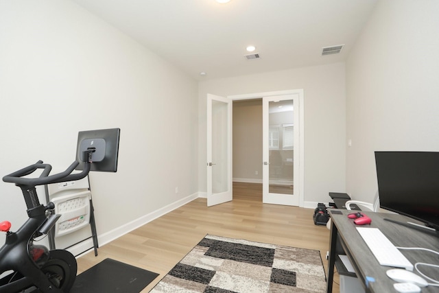 workout room with visible vents, baseboards, french doors, and light wood-style floors