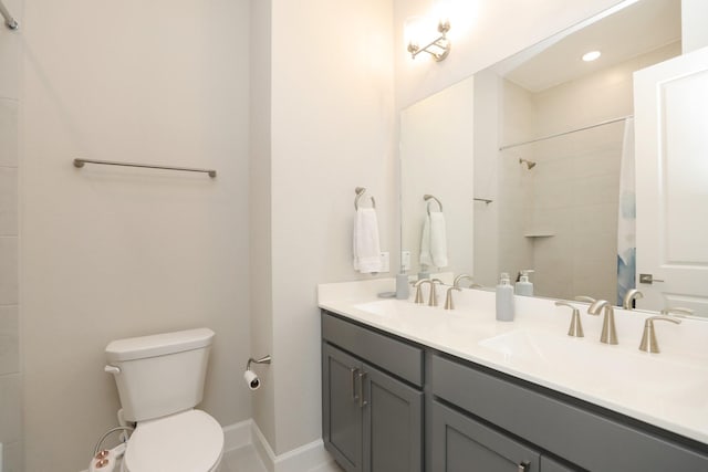 bathroom featuring toilet, a shower with curtain, double vanity, and a sink