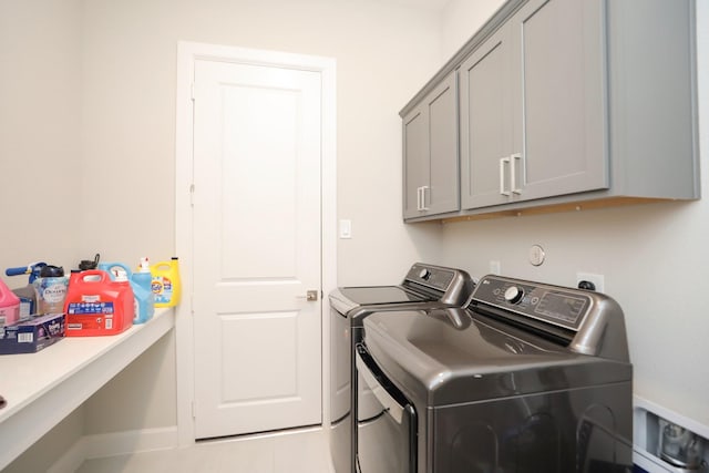 clothes washing area featuring washer and dryer and cabinet space