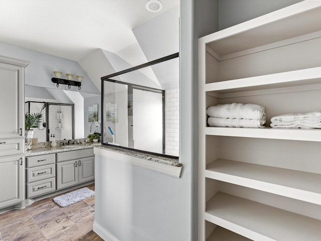 4138 Defender Ln, Galveston, TX 77554 - bathroom with a shower stall, lofted ceiling, and vanity