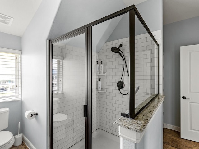 4138 Defender Ln, Galveston, TX 77554 - bathroom with baseboards, visible vents, a stall shower, and toilet