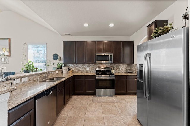 kitchen featuring a sink, stainless steel appliances, tasteful backsplash, visible vents, and dark brown cabinets