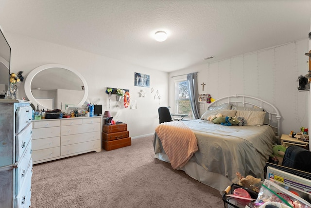 bedroom with visible vents, carpet floors, and a textured ceiling