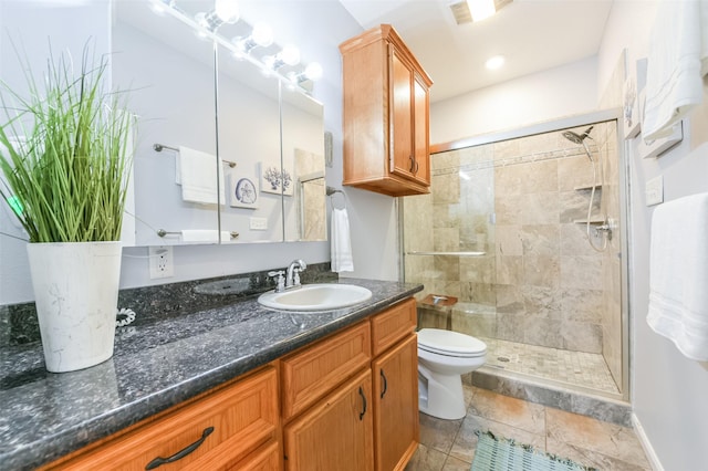 bathroom featuring toilet, vanity, a shower stall, and visible vents