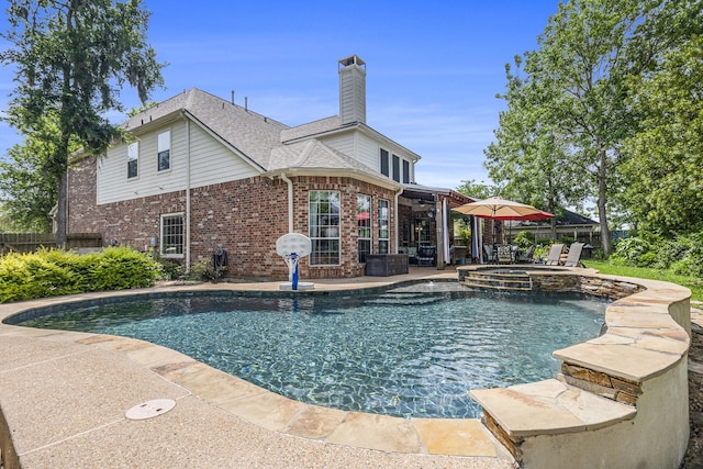 view of swimming pool featuring a patio, a pool with connected hot tub, and fence