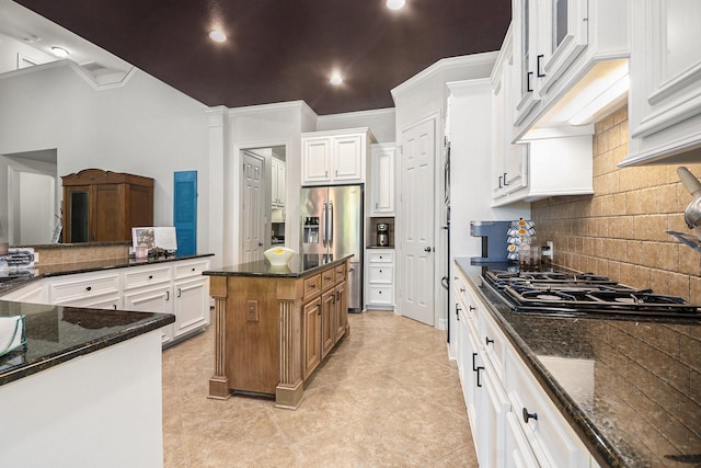 kitchen with dark stone countertops, black gas cooktop, tasteful backsplash, and a center island