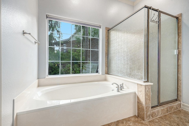 full bath with tile patterned floors, a shower stall, a garden tub, and a textured wall