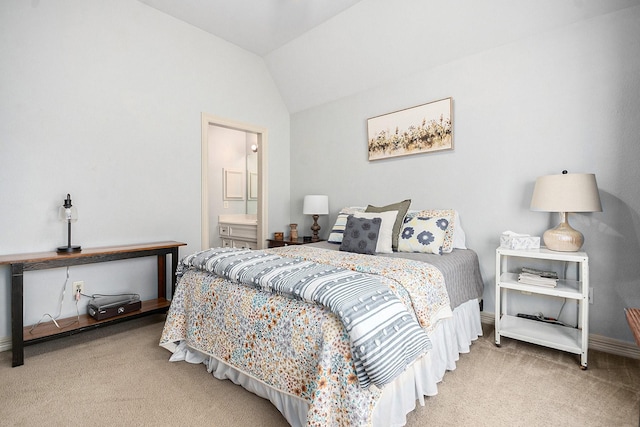 bedroom featuring baseboards, vaulted ceiling, carpet, and ensuite bathroom