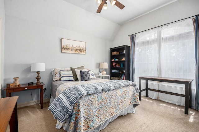 carpeted bedroom with a ceiling fan, vaulted ceiling, and baseboards