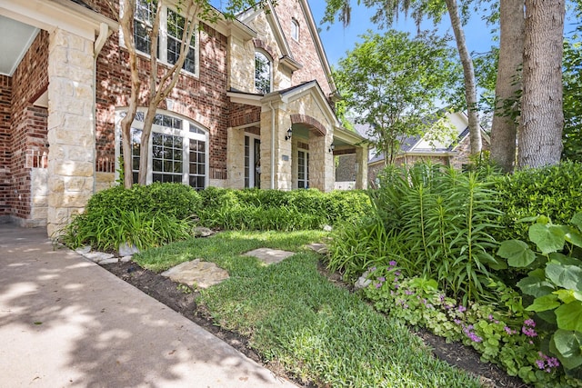 entrance to property featuring stone siding and brick siding