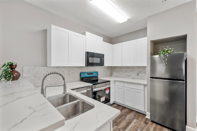 2626 Holly Hall Unit 101, Houston, TX 77054 - kitchen with a sink, appliances with stainless steel finishes, backsplash, and white cabinets