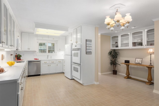 710 Alyse St, Deer Park, TX 77536 - kitchen with white appliances, an inviting chandelier, white cabinetry, a sink, and baseboards