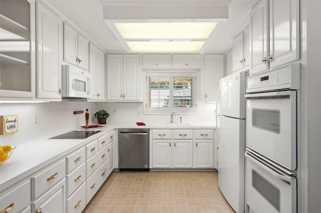 710 Alyse St, Deer Park, TX 77536 - kitchen featuring white cabinetry, white appliances, light countertops, and a sink