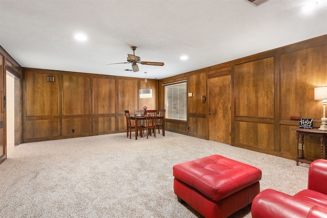 710 Alyse St, Deer Park, TX 77536 - living area with wood walls, ceiling fan, and carpet floors