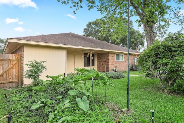 710 Alyse St, Deer Park, TX 77536 - rear view of house featuring a lawn, a shingled roof, and fence