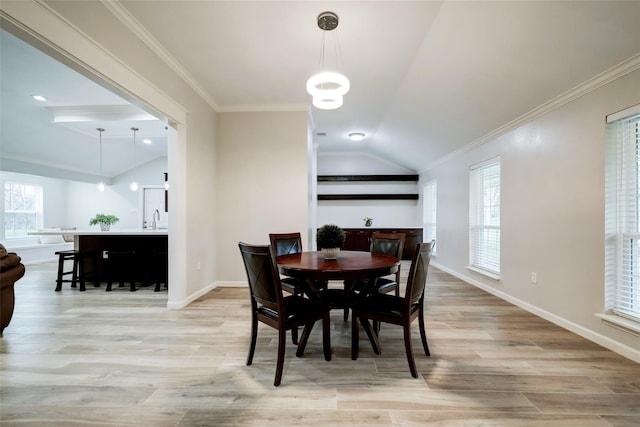 dining space featuring light wood-type flooring, plenty of natural light, vaulted ceiling, and baseboards
