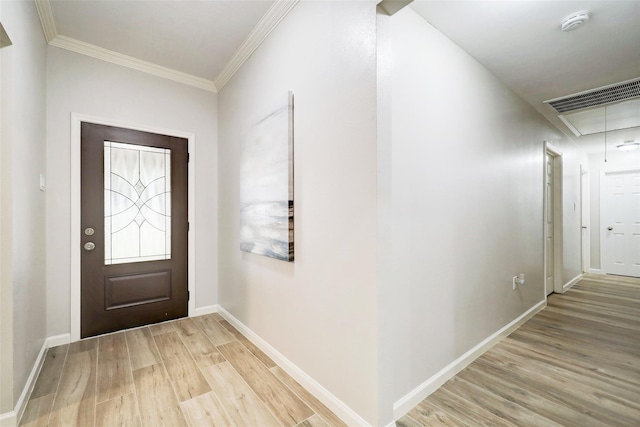 foyer entrance with visible vents, light wood-style floors, ornamental molding, and baseboards