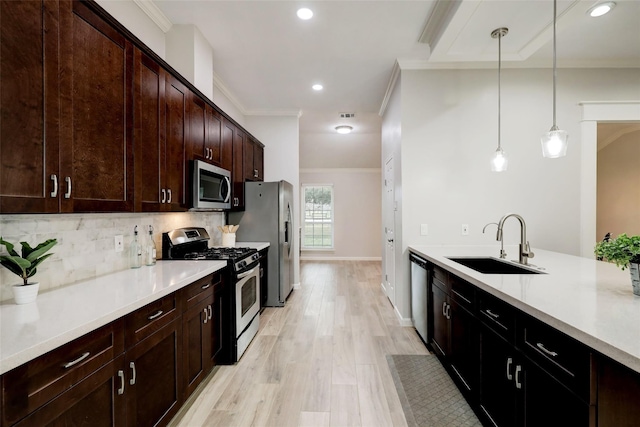 kitchen with tasteful backsplash, appliances with stainless steel finishes, light countertops, and a sink