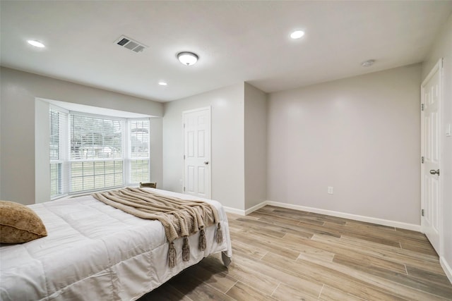 bedroom featuring light wood finished floors, recessed lighting, visible vents, and baseboards