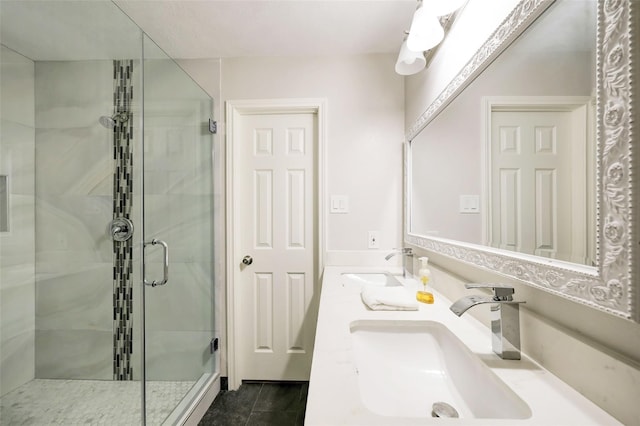 bathroom featuring a stall shower, double vanity, and a sink