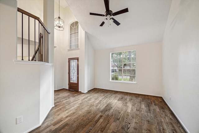unfurnished living room featuring baseboards, ceiling fan with notable chandelier, and wood finished floors